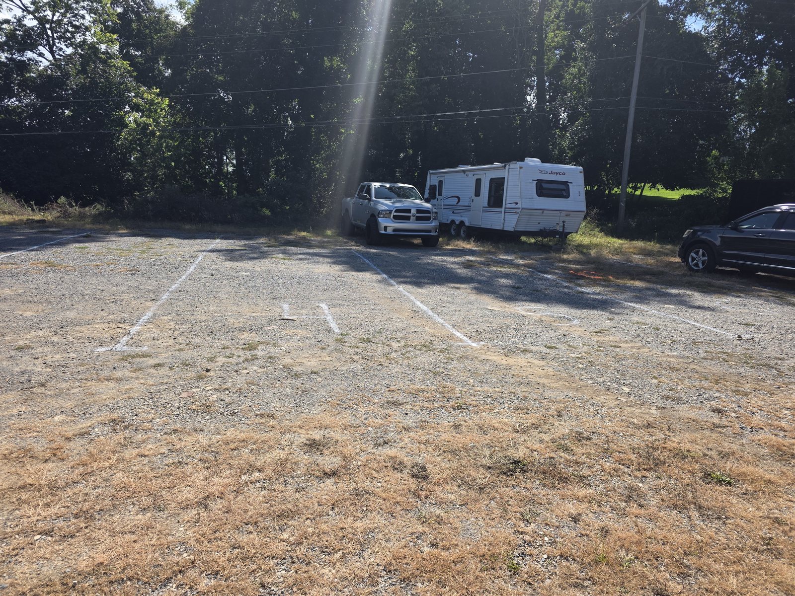 A pickup truck and a Jayco travel trailer parked in marked spaces on the outdoor lot at Safe Haven Storage
